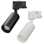 Two cylindrical LED track lights with visible lens front, one black and one white, mounted on track adapters with electrical 