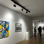 LED track lighting system with three black spotlights mounted on a 1-meter rail, illuminating gallery artworks on white walls