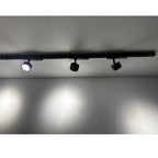 Three black LED spotlights mounted on a 1-meter track rail against a white ceiling, with the leftmost light illuminated.