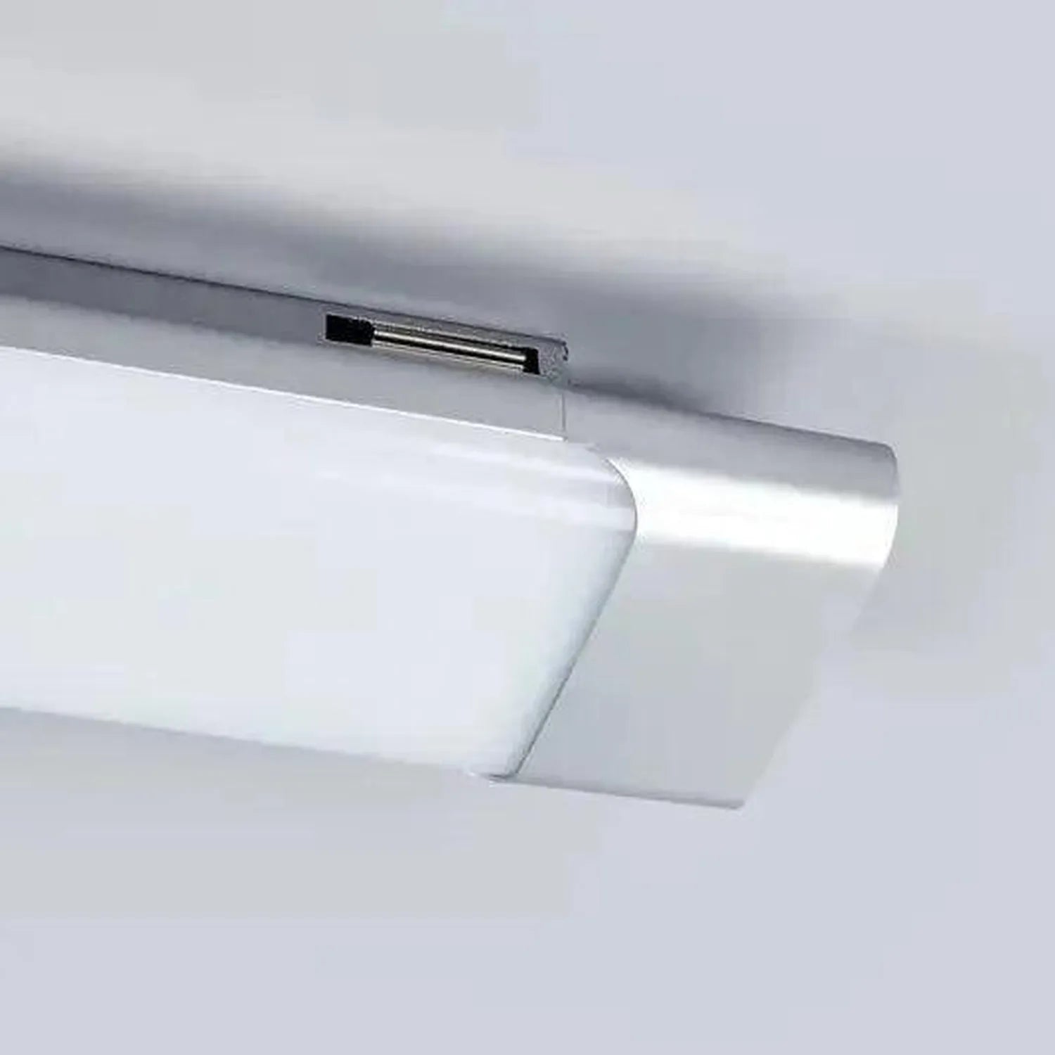 Ceiling-mounted LED batten light with grey aluminium frame and white diffuser panel, installed against white ceiling.