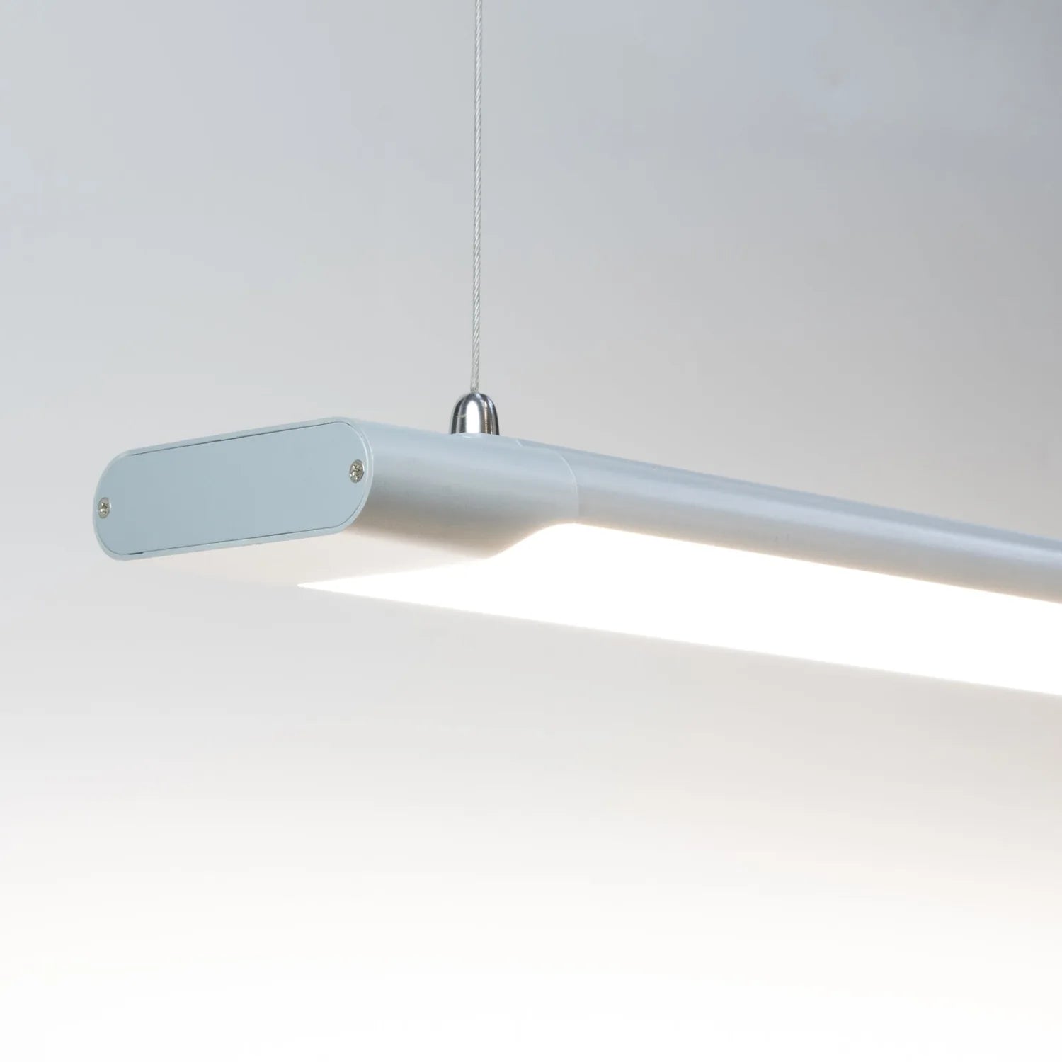 Voltaled Uranus LED batten light suspended against white background, showing elongated grey fixture with bright white light s
