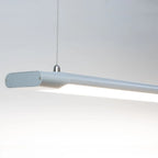 Modern grey LED batten pendant light with elongated rectangular form and hanging cable against white background.