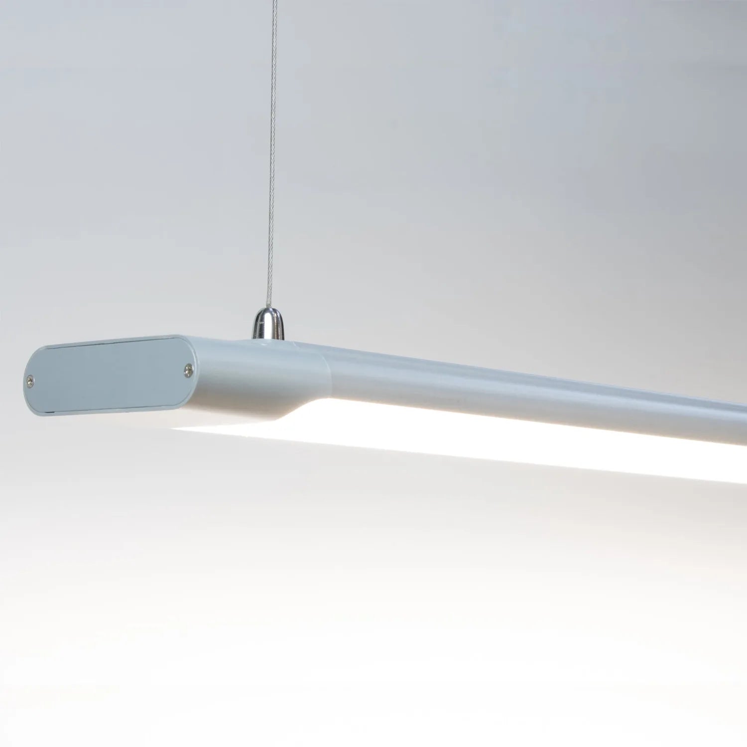 Modern grey LED batten pendant light with elongated rectangular form and hanging cable against white background.