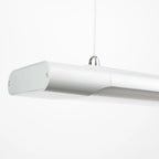 White cylindrical LED batten light suspended by cord, shown against plain background.