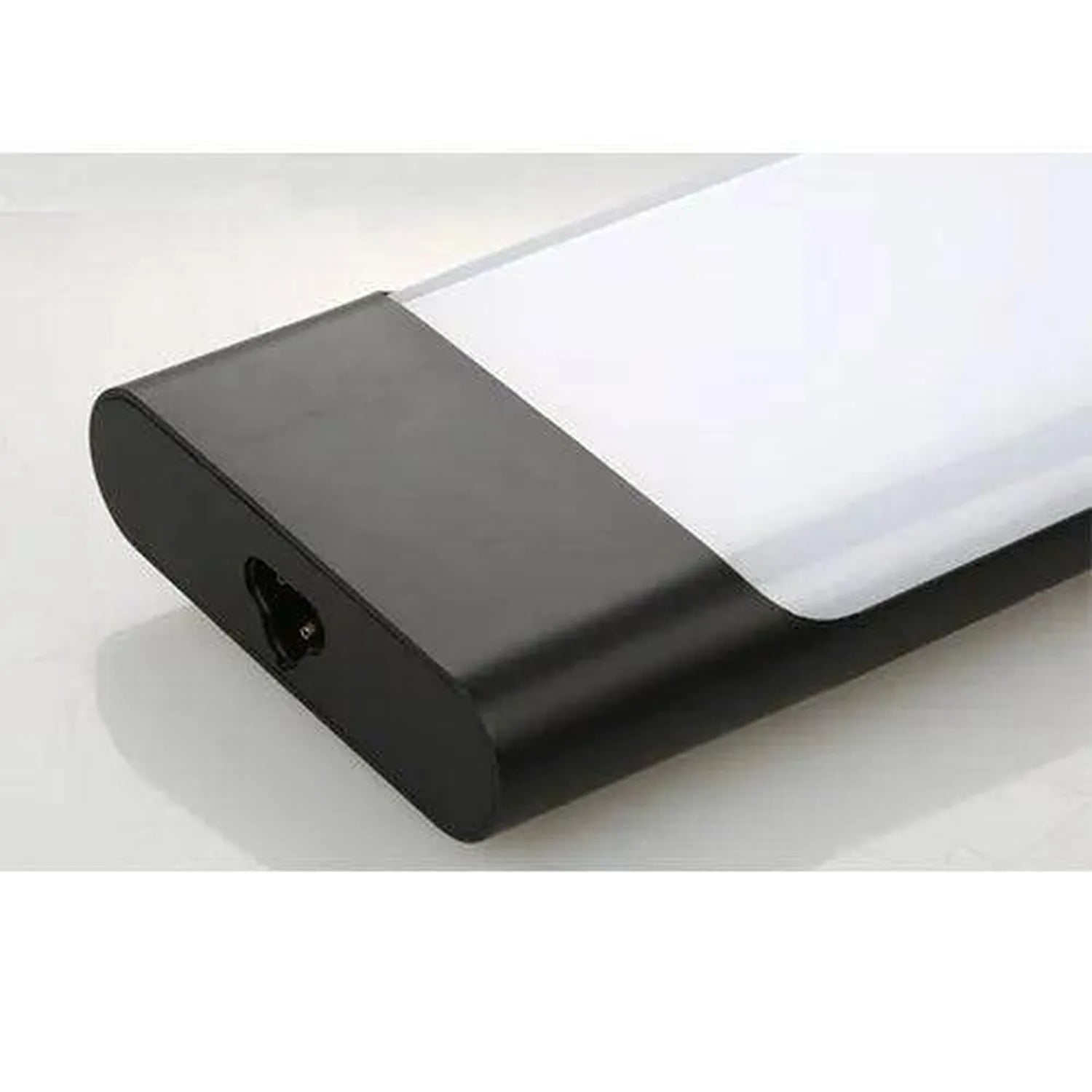 Black cylindrical LED batten light fixture with white diffuser, angled product shot on white surface.