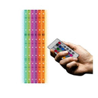Hand holding remote control next to six vertical RGB LED light strips in rainbow colors from teal to orange.