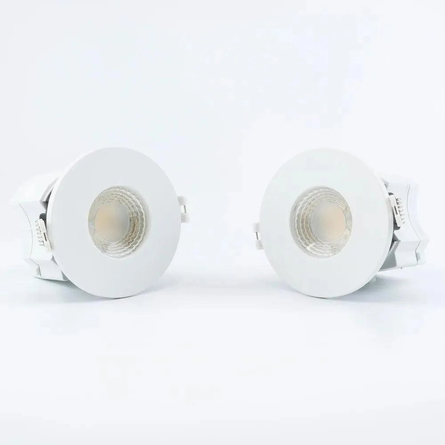 Pair of white recessed LED downlights with circular trim rings and visible lamp heads, displayed against a light background.