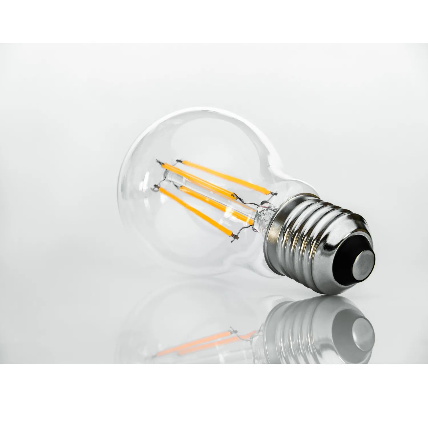 LED filament bulb with warm white glowing filaments inside clear glass globe, metallic E27 screw base, product shot on white 
