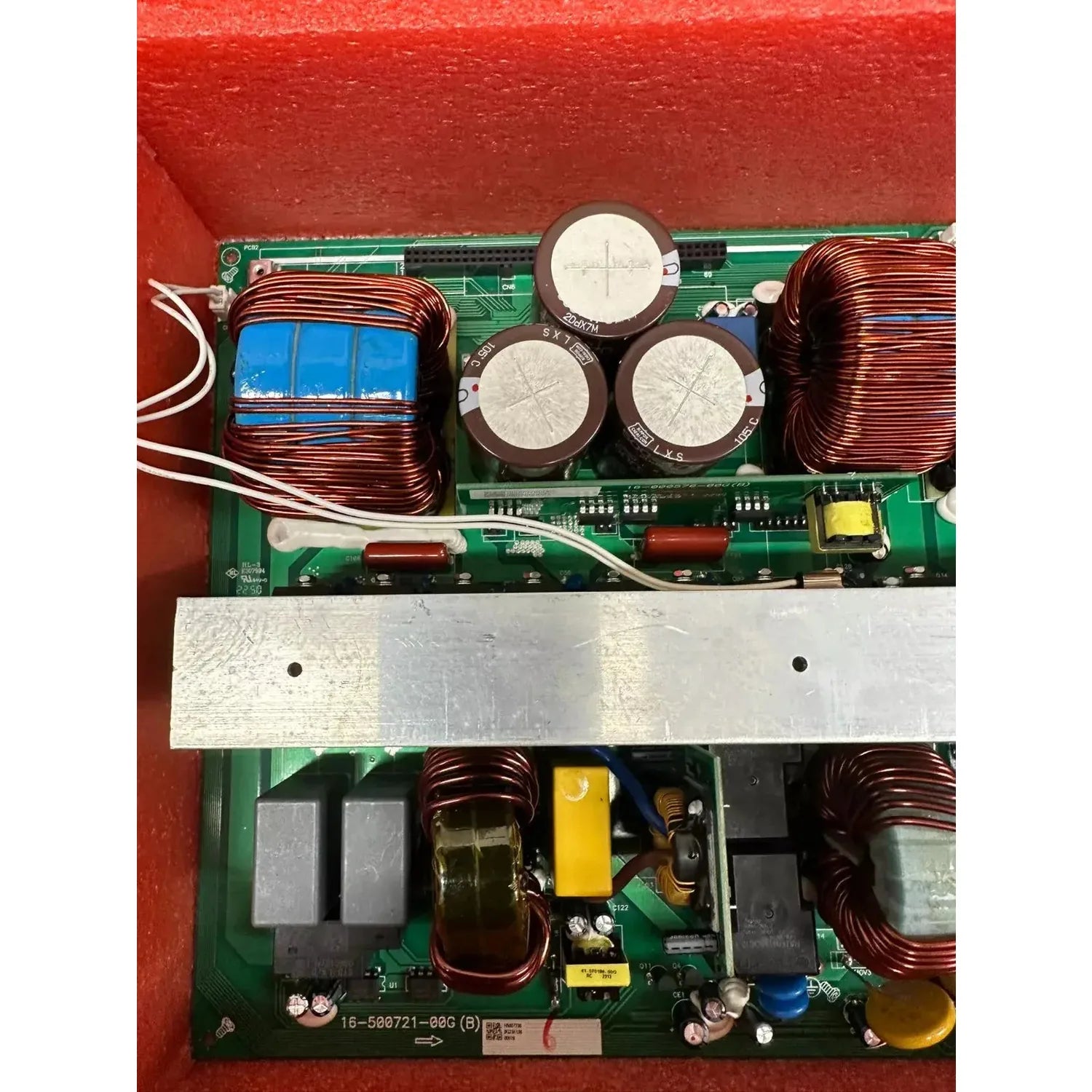 Internal circuit board assembly with copper coils, capacitors, and transformers in red metal housing