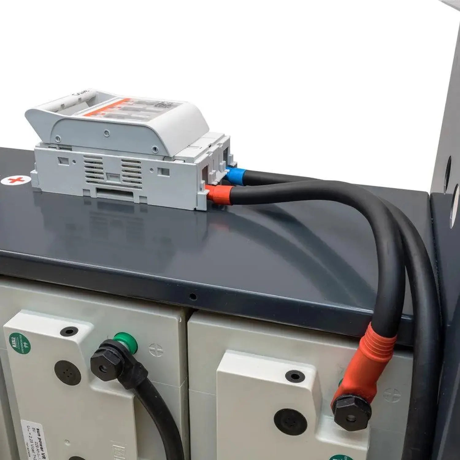 Hoppecke Sun Power Classic battery system installation showing white junction box with blue and red connectors mounted on dar