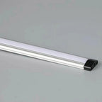 LED strip light with frosted diffuser and black end cap on neutral background, product alone.
