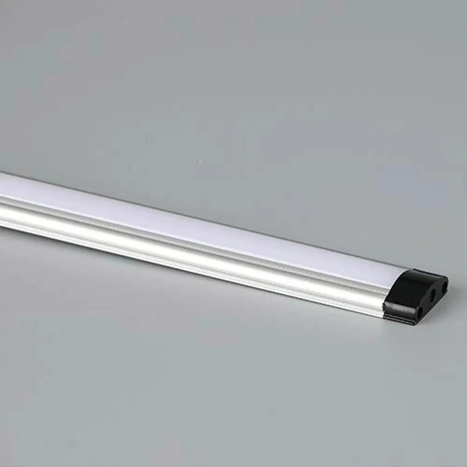LED strip light with frosted diffuser and black end cap on neutral background, product alone.