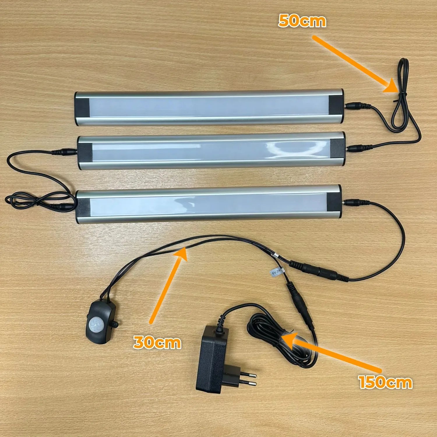 LED cabinet lighting kit with three aluminum strip lights, motion sensor, power adapter, and cables labeled with dimensions o
