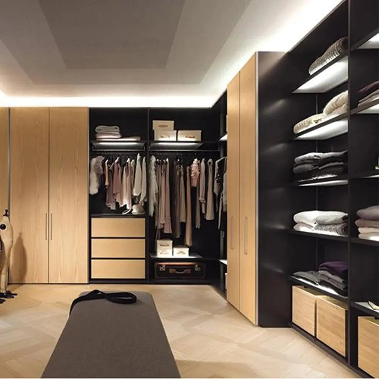 Modern walk-in closet with wooden cabinetry, black shelving, clothing racks, and illuminated shelves displaying folded linens