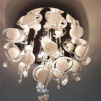 Modern ceiling fixture with frosted glass globe pendants and crystal accents hanging from chrome canopy, installation shot.