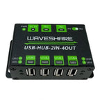 Waveshare USB-HUB-2IN-4OUT hub showing top view with four USB ports, power indicator, and green control switches for dual inp