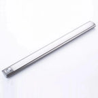 Silver and white LED under cabinet light with touch control button, angled view against white background.