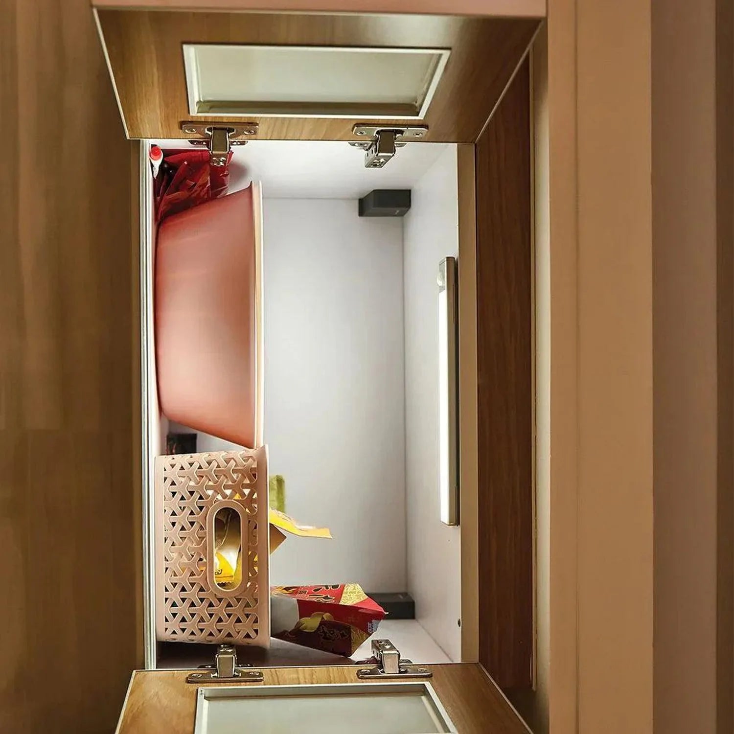 LED Blade under cabinet light installed inside wooden cabinet, illuminating decorative items with warm light from metal fixtu