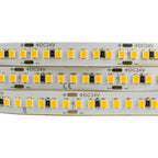 Close-up of LED strip showing three parallel rows of yellow SMD2835 diodes with resistors on 24V DC flex circuit board.