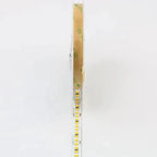 Rolled LED strip light with white backing and yellow SMD diodes, packaged in clear plastic sleeve with tan kraft paper wrappe
