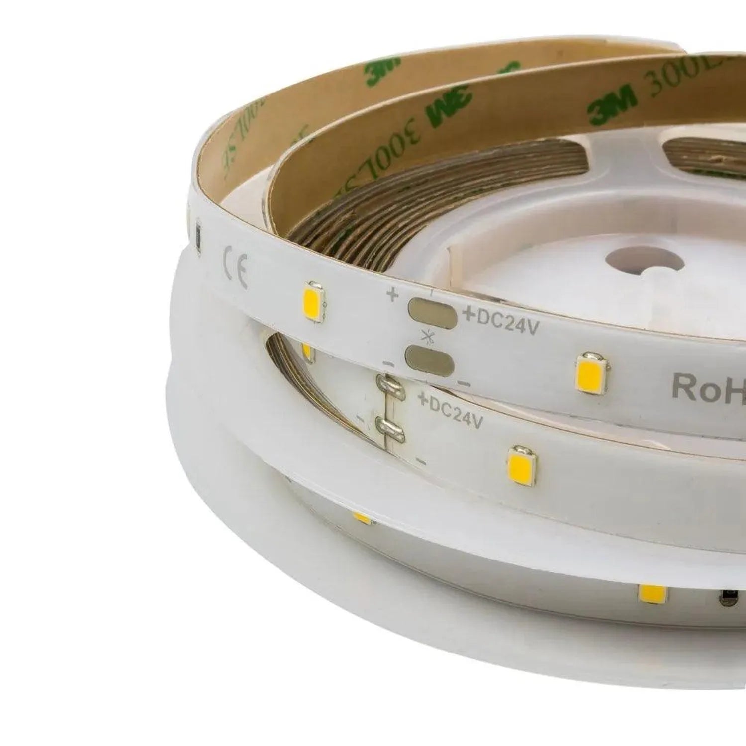 Rolled LED light strips with yellow SMD chips on white backing, labeled +DC24V and RoHS compliant, tan adhesive side visible.