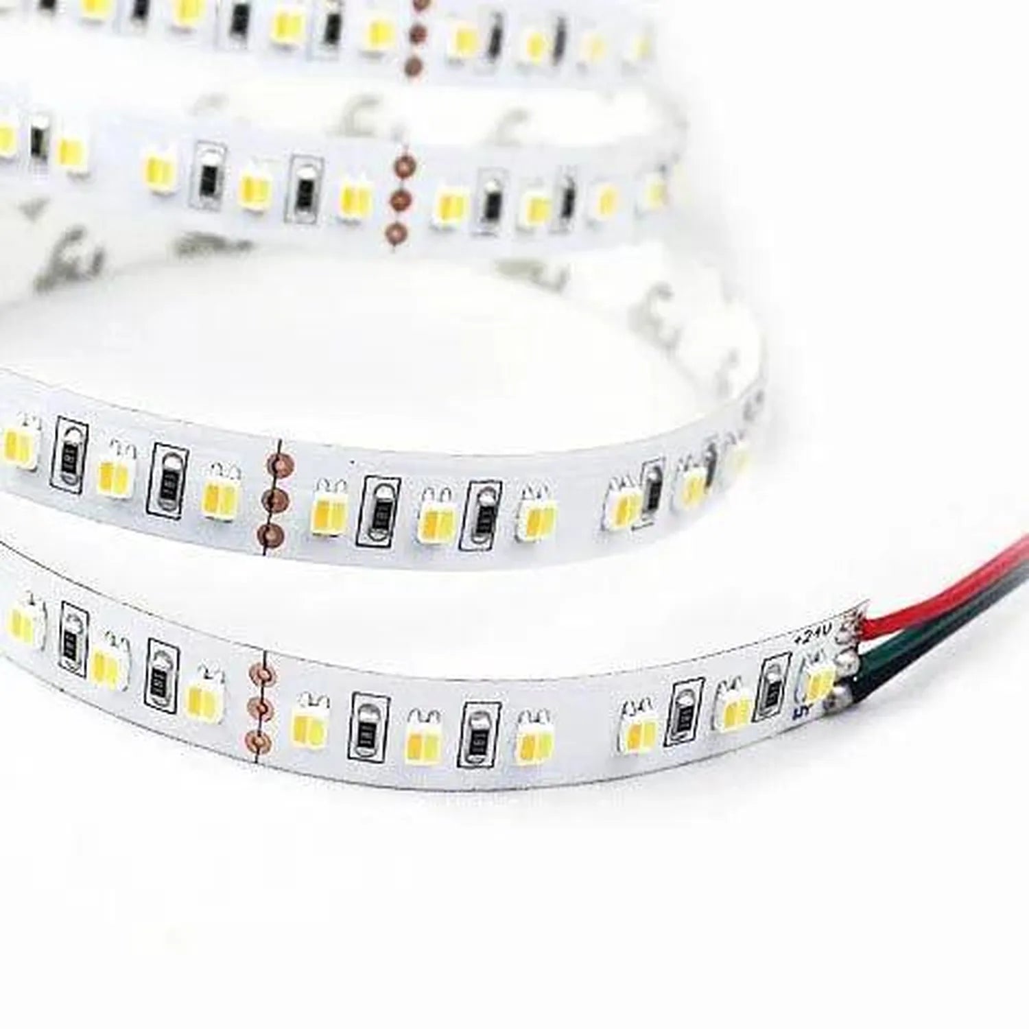 Coiled LED strip light with yellow and white SMD LEDs alternating with black control modules and copper solder pads, with red