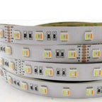 Coiled RGB and warm white LED strip light showing multiple rows of LED chips, connectors, and 24V power terminals on flexible