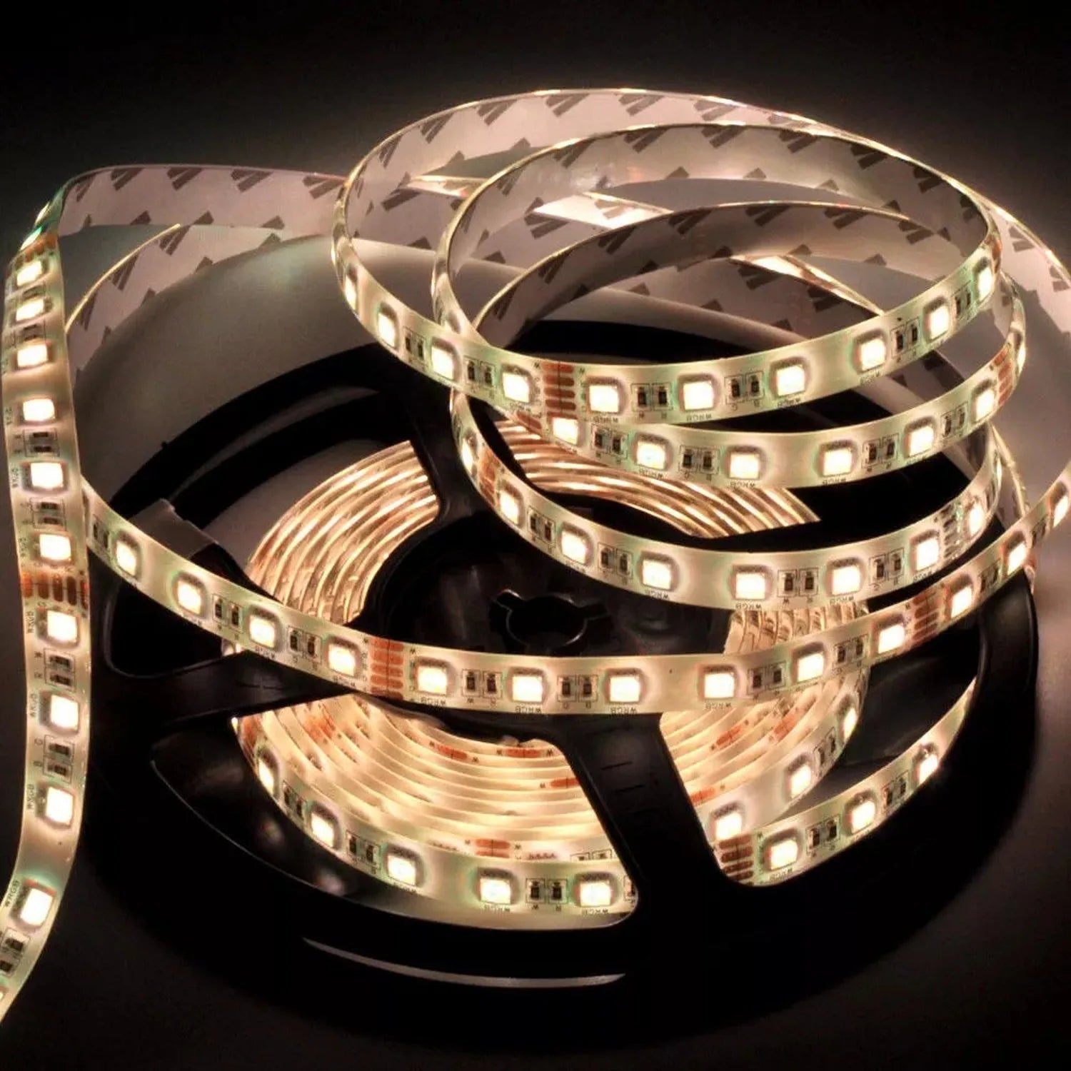 Coiled LED strip light with warm white LEDs and copper circuitry visible on black reel, product shot on dark background.