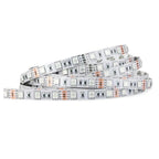 Coiled RGB LED strip light with white backing, copper connectors, and black circuit components visible on flexible substrate.