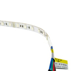 Flexible LED strip light with exposed circuit components and solder points, curved to show flexibility, with multicolored wir