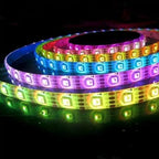 Coiled RGB LED strip lights in multiple colors including blue, green, yellow, pink, and purple, glowing against a dark backgr