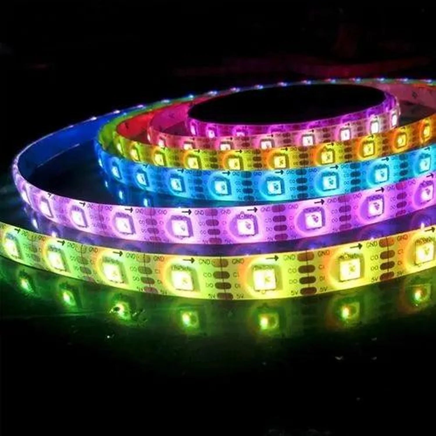Coiled RGB LED strip lights in multiple colors including blue, green, yellow, pink, and purple, glowing against a dark backgr