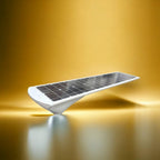 White solar panel with dark photovoltaic cells mounted on curved base, displayed against gold background.