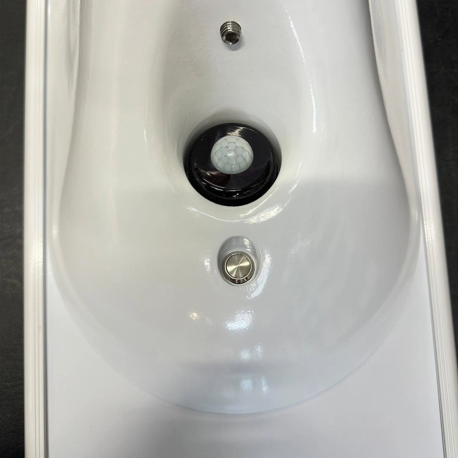 White ceiling-mounted solar light fixture with motion sensor dome, power button, and threaded connector, installation shot.