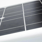 Close-up of solar panel array with white frame and gridded black photovoltaic cells.