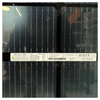 JA Solar 450-watt bifacial solar panel front surface showing grid pattern with metallic contacts and product label with speci