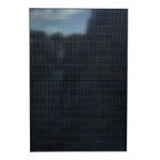 Full black solar panel with vertical ribbed texture and mountains visible at top horizon line.