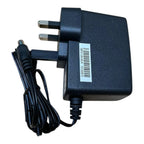 Black UK mains power adapter with folding prongs, DC barrel connector, and barcode label visible on body.