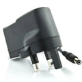 Black UK mains power adapter with two rectangular pins and DC connector cable, angled view against white background.