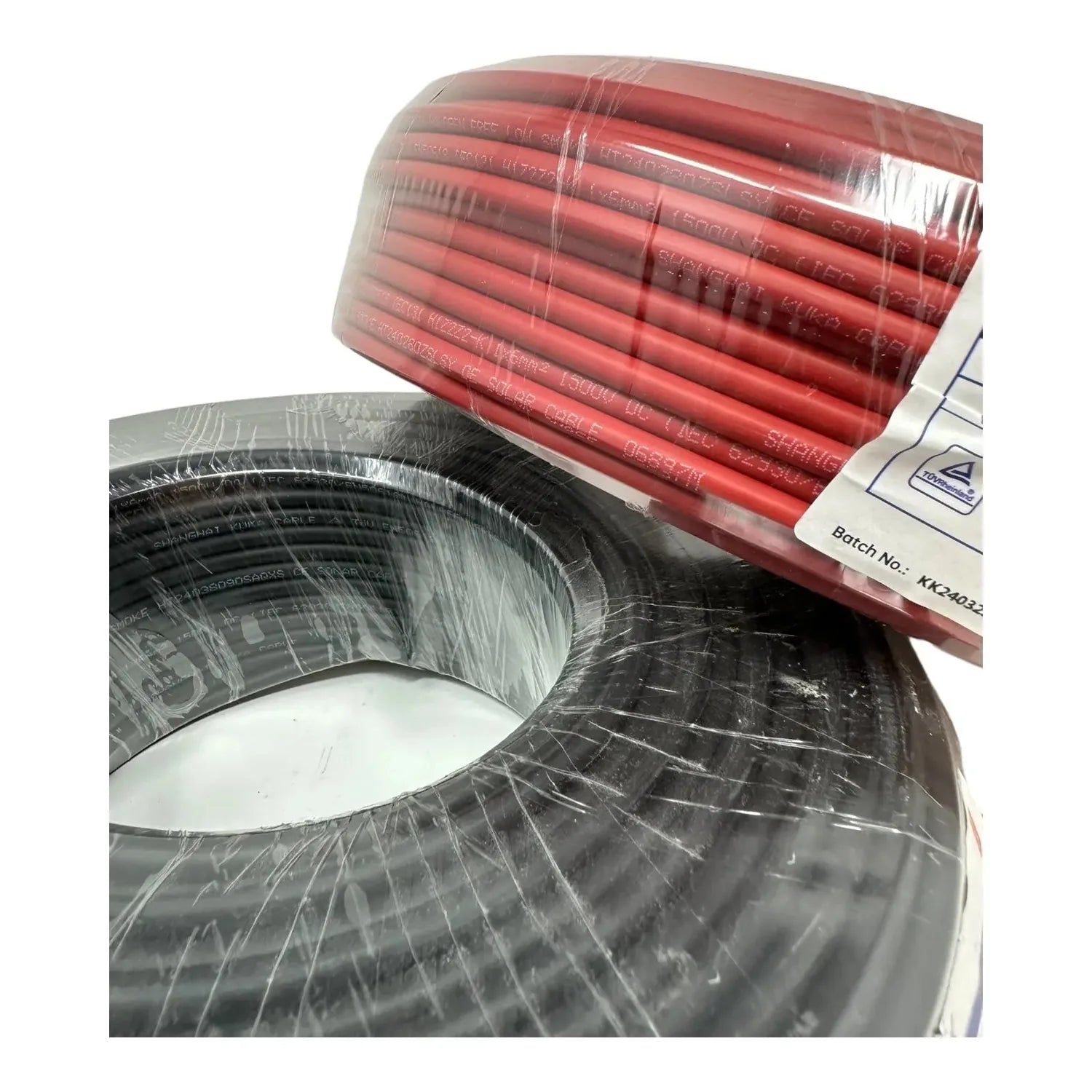 Coiled red and black solar PV cables on drums, wrapped in plastic with batch number label visible.