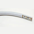 Curved aluminum LED profile strip with integrated LED components and connector ports visible on the end section, shown agains