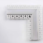 White metal corner trim with circular perforations and integrated LED profile channel for drywall installation.