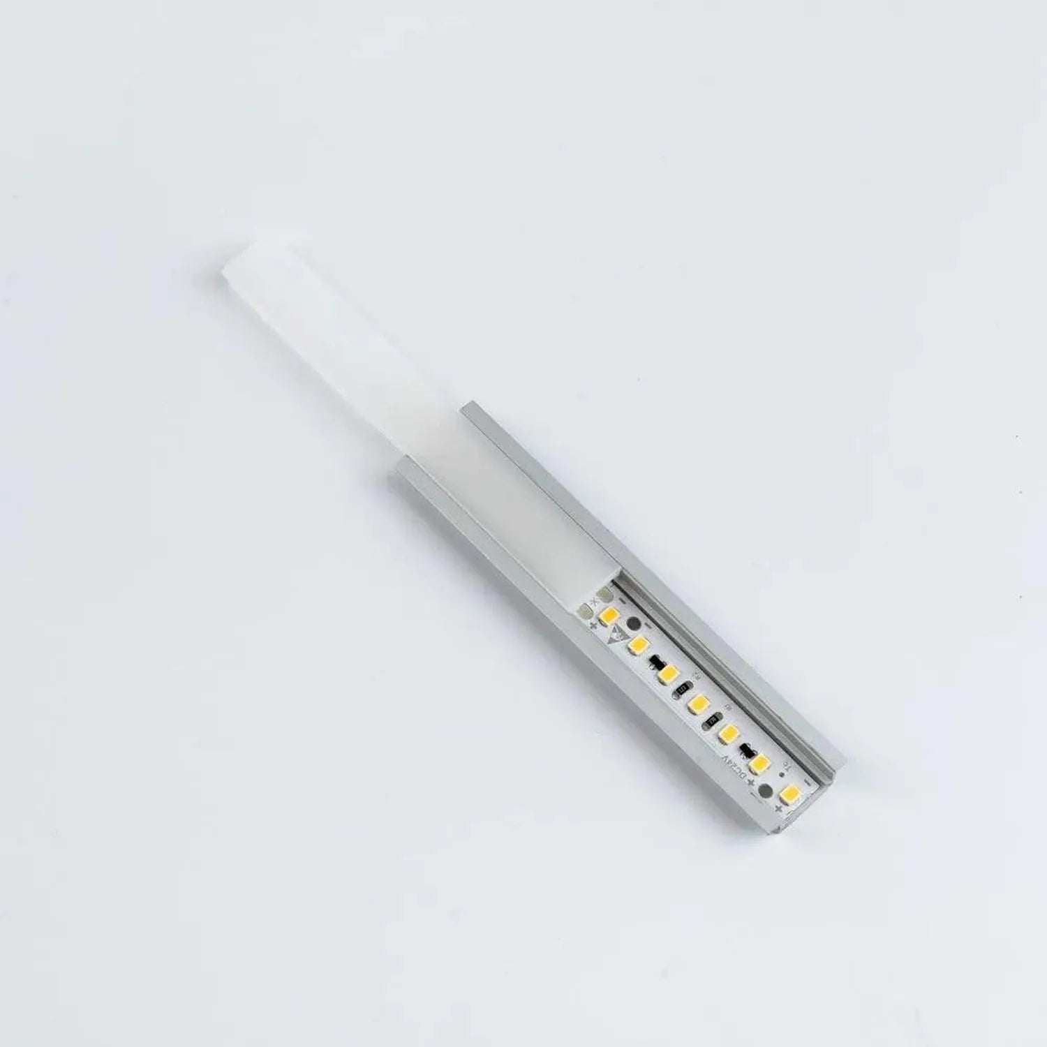 Aluminum LED channel profile with frosted diffuser and yellow LED strip mounted inside, angled view on white background.