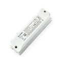 White rectangular LED driver with ribbed cooling fins, mounting holes, and technical specifications label visible, angled vie