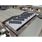 Aerial installation shot of solar panels mounted on flat industrial roof using adjustable triangle brackets, industrial compl