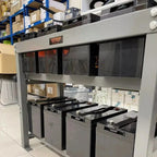 Voltacon display unit showing eight 6V 200Ah gel batteries arranged in rows, installed in warehouse setting with shelving vis