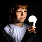 Child holding illuminated white LED globe bulb against dark background, demonstrating warm glow of 5W E27 bulb.