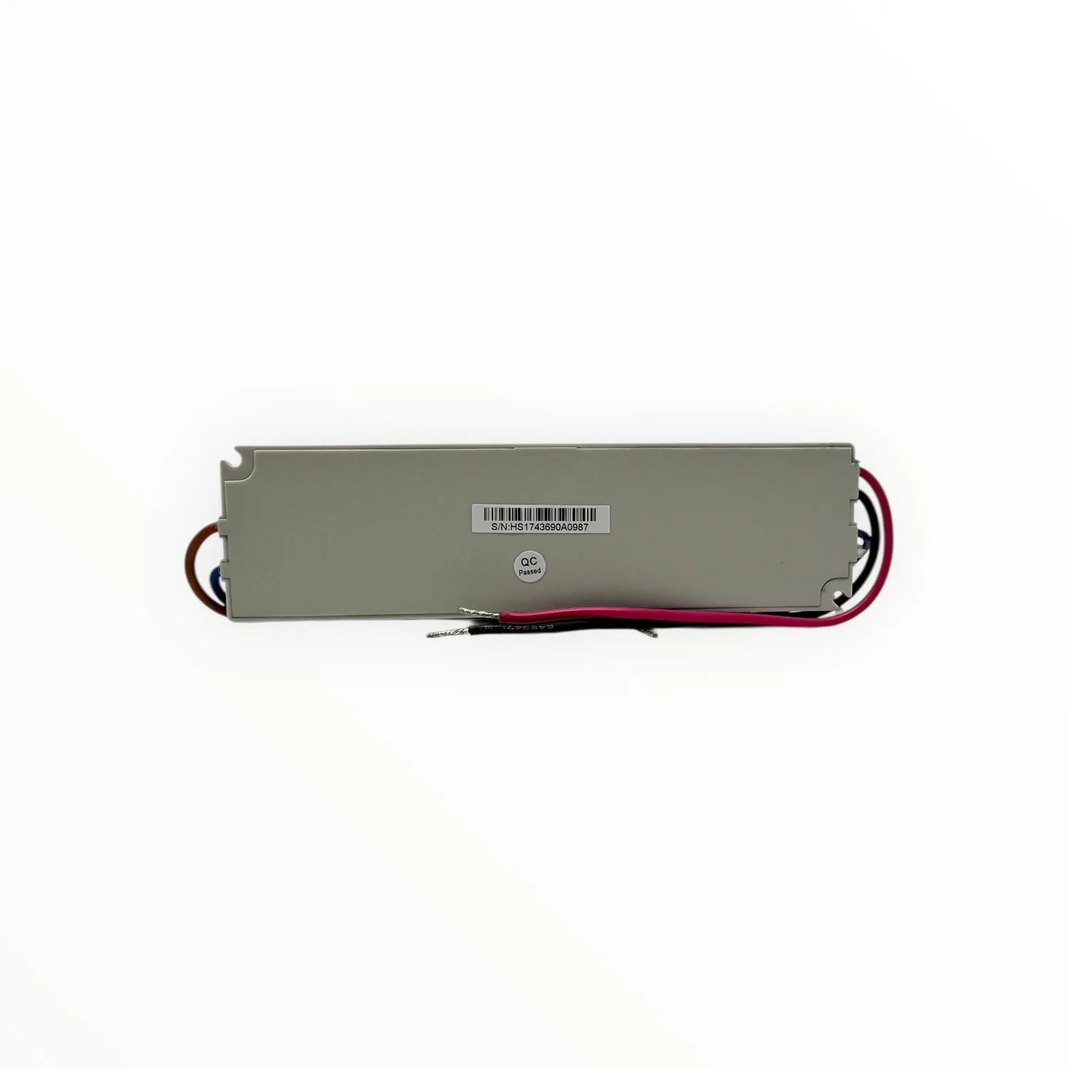 Linear LED strip driver with gray metal housing, red and black wires, serial number label, and QC passed sticker visible.