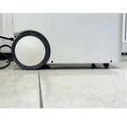 White portable power station with black wheels and power cable, shown on marble floor from side angle.