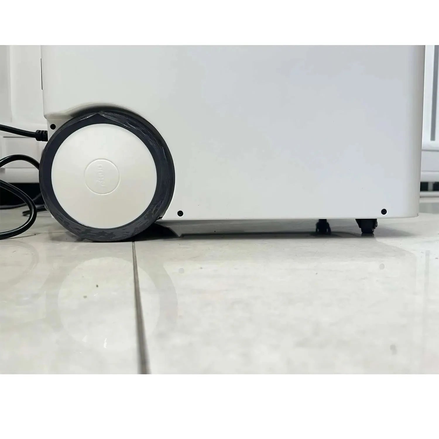White portable power station with black wheels and power cable, shown on marble floor from side angle.